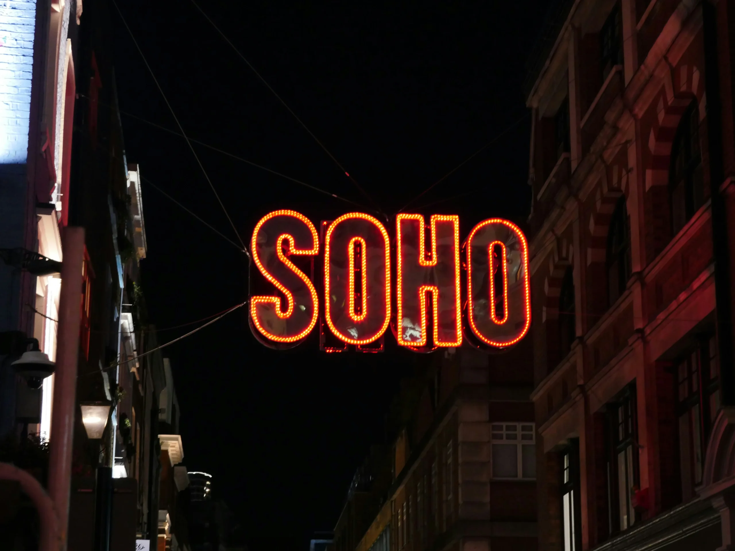A lively Soho street in London at dusk