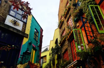 Colorful storefronts and lush greenery along the vibrant streets of Covent Garden in London.
