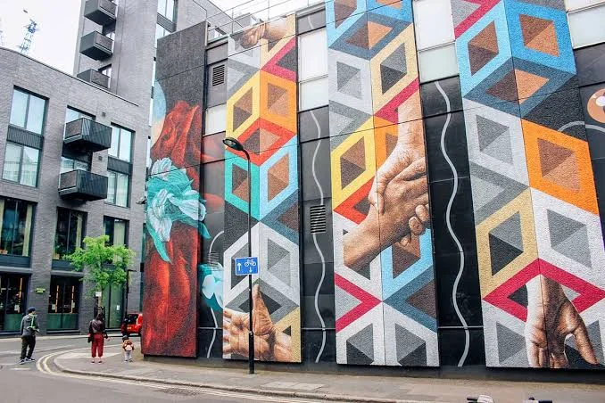 Colourful street art mural on a brick wall in Shoreditch East London.
