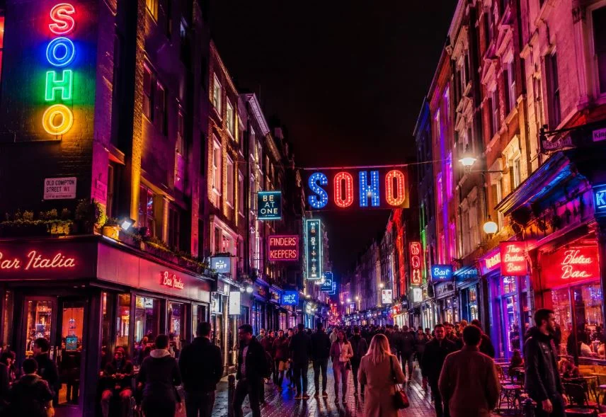 Busy neon-lit Soho street at night in London's West End