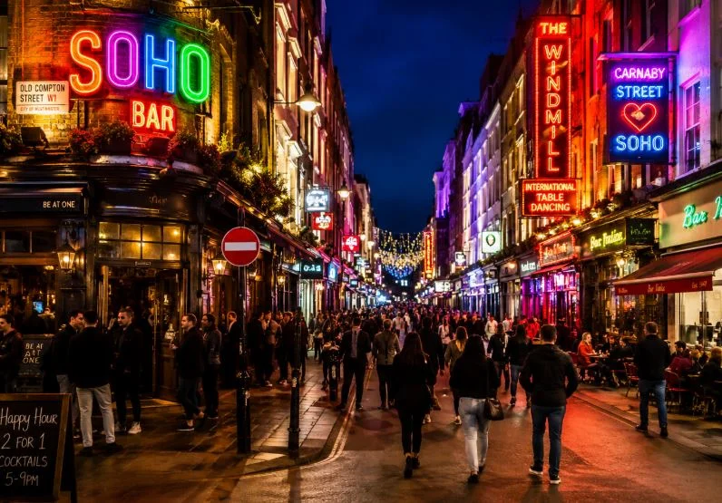 Busy neon-lit Soho street at night in London's West End