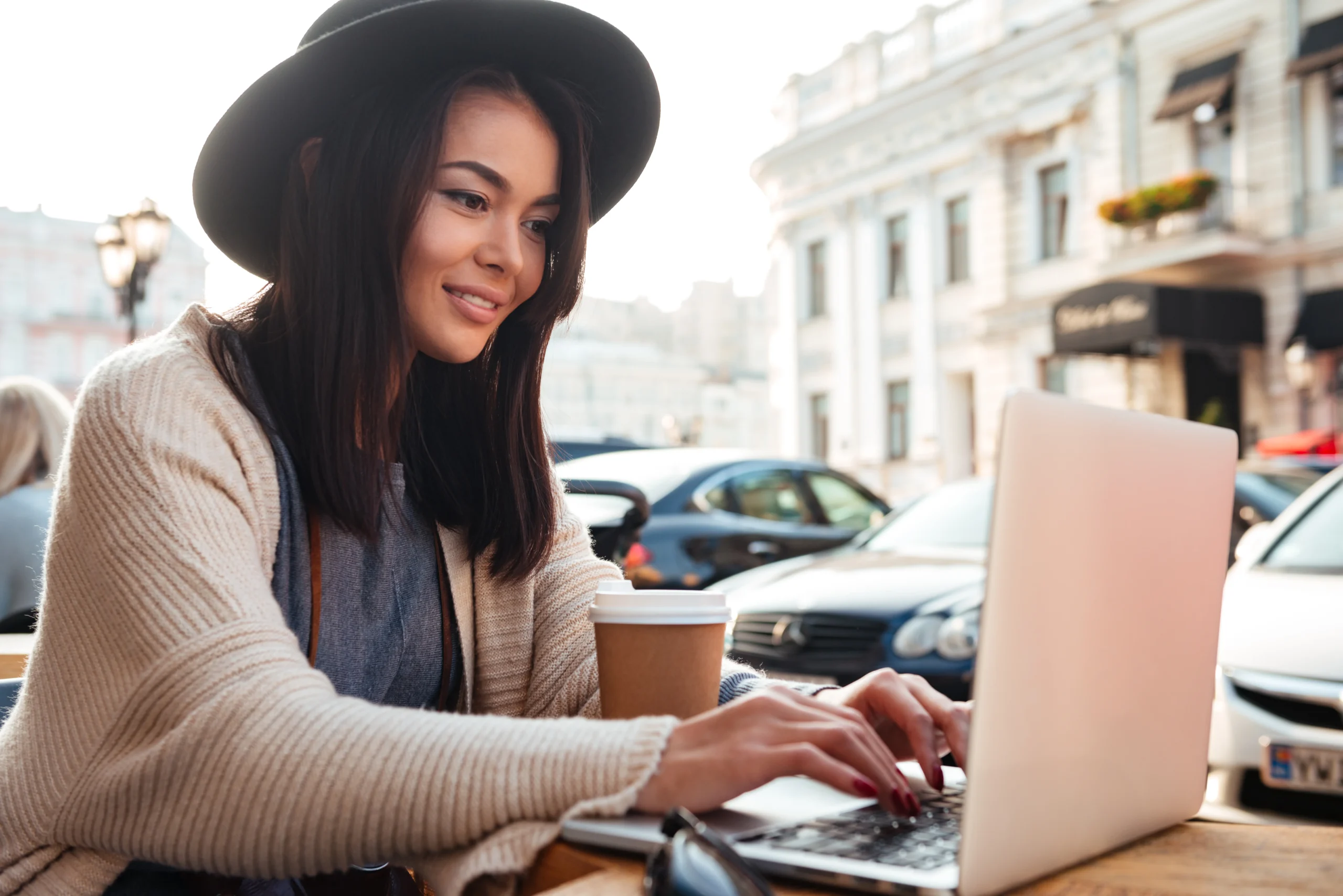 Traveller checking hotel prices on laptop with London map open
