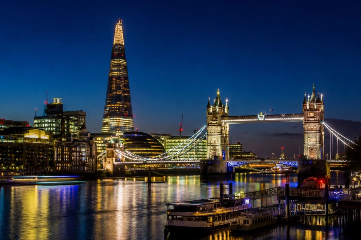 London skyline at night with Tower Bridge and the Shard illuminated over the River Thames.